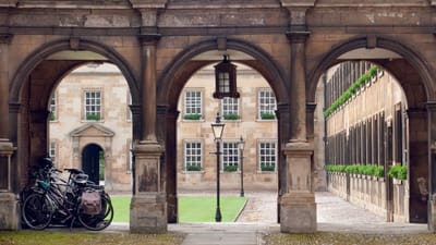Historischer Innenhof des Peterhouse College in Cambridge mit Arkadengang und Fahrrädern